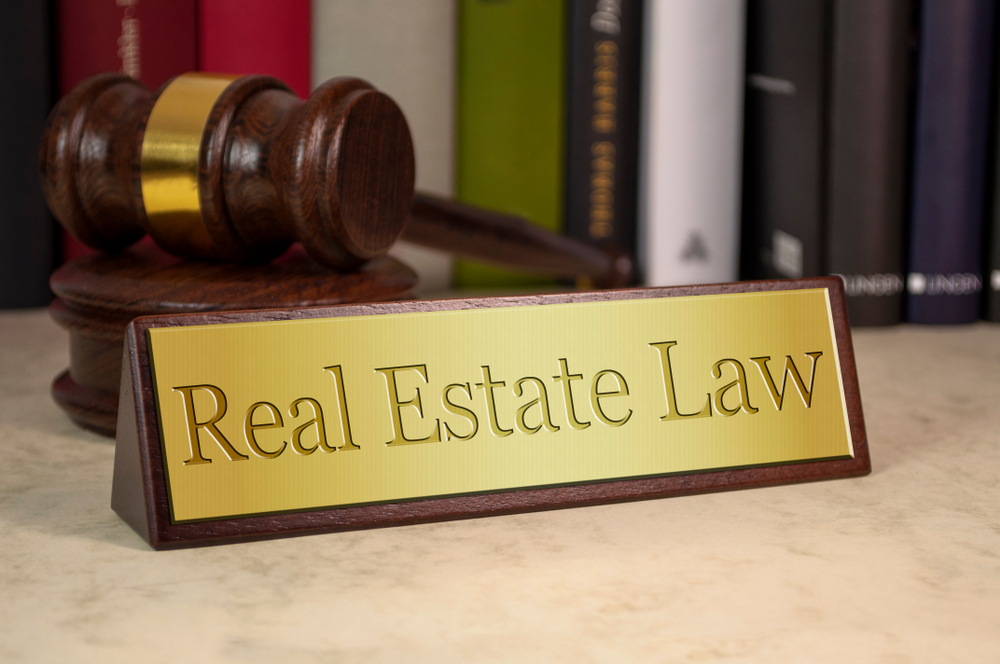 a wooden sign that says real estate law pujol law